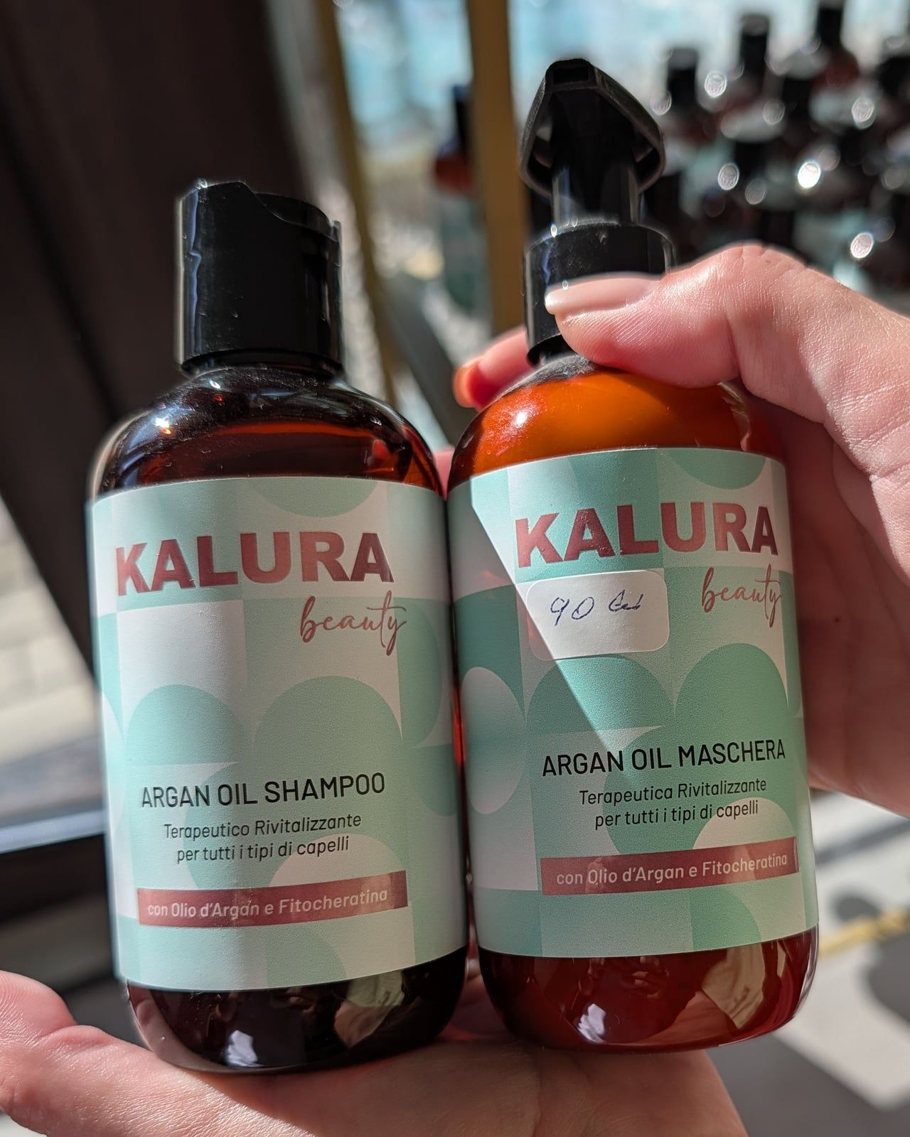 Flacoanele Kalura Beauty Argan Oil Shampoo și Argan Oil Maschera, ținute în palmă